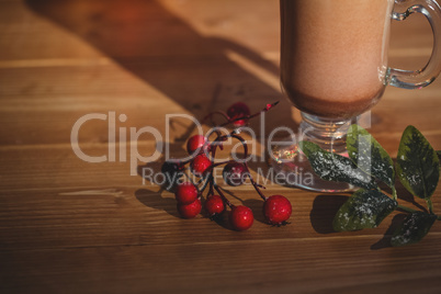 Cup of coffee with cherry on wooden table