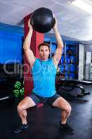 Portrait of serious athlete holding exercise ball