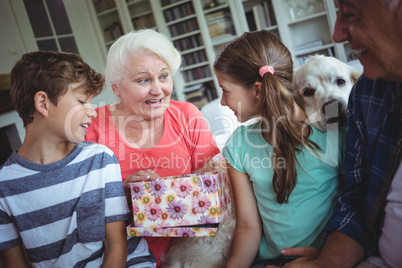 Grandparents and grandchildren looking at surprise gift in living room