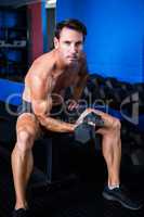 Portrait of young athlete lifting dumbbell