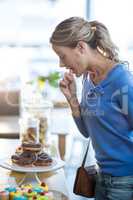 Woman looking at doughnut at counter