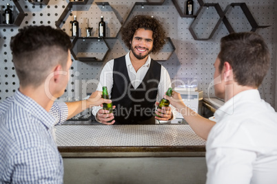 Bartender serving glass of beer to customers