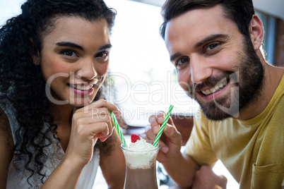 Couple having milkshake in coffee shop