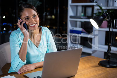 Businesswoman talking on mobile phone in office