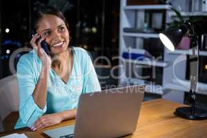 Businesswoman talking on mobile phone in office