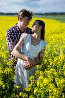 Romantic couple standing in mustard field