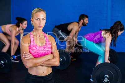 Woman standing while people exercising in background