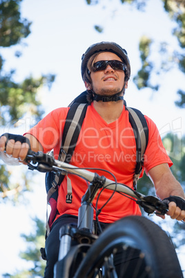 Male mountain biker riding bicycle in the forest