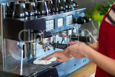 Waitress wiping espresso machine with napkin in cafÃ?Â©