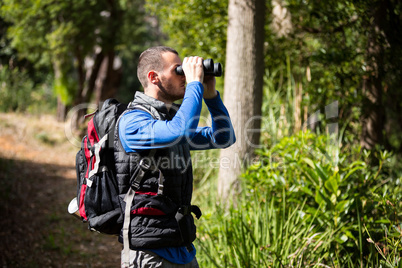 Male hiker looking through binoculars