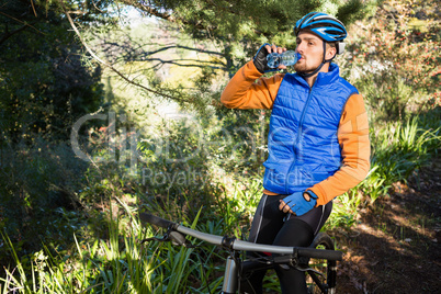 Male mountain biker drinking water