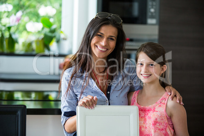 Portrait of mother and daughter together in living room