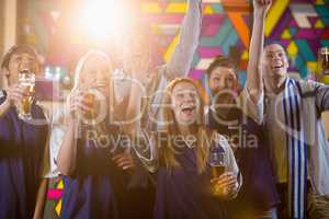 Group of friends cheering in party while having glass of champagne