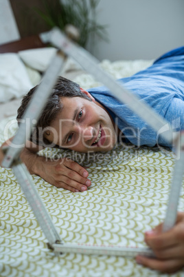 Man playing with a model house in bedroom