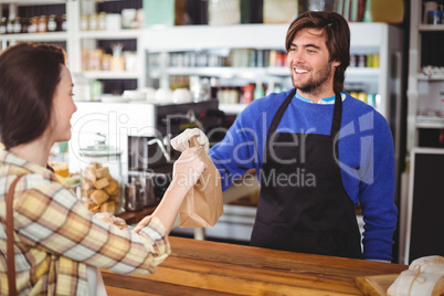 Waiter giving parcel to customer at counter