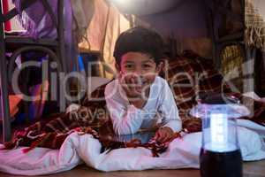 Boy with digital tablet relaxing on mattress