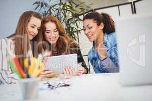 Businesswomen looking at digital tablet at desk