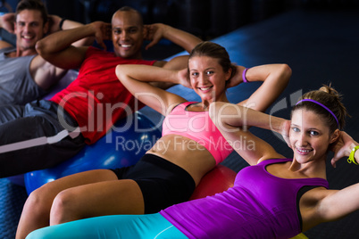 Portrait of smiling friends with hands behind back while stretching
