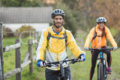 Biker couple with mountain bike in countryside