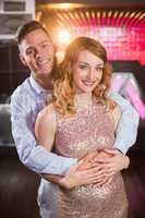 Smiling couple embracing each other in bar