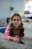 Girl watching tv lying on the rug in the living room