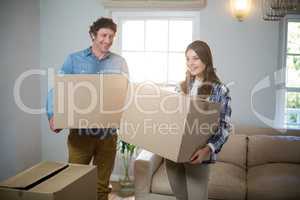 Couple holding cardboard boxes