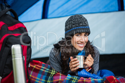 Portrait of smiling hiker having a cup of coffee in tent