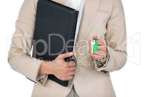 Businesswoman holding a file and key against white background