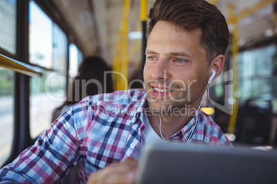 Handsome man listening music on digital tablet
