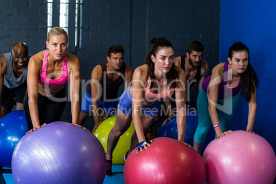 Athletes exercising with fitness ball in gym