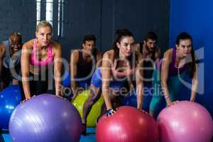Athletes exercising with fitness ball in gym