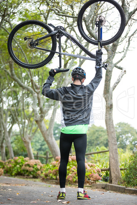 Male cyclist carrying mountain bike