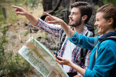 Hiker couple holding map and showing direction