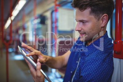 Handsome man using digital tablet in train
