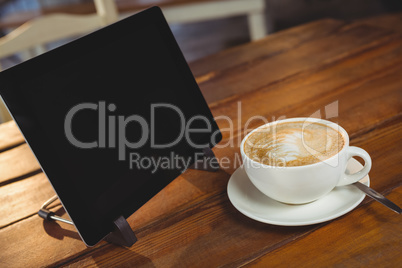 Cappuccino and digital tablet on table