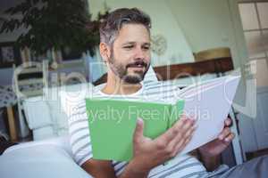 Father looking at photo album in living room