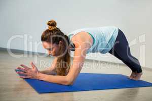 Woman performing yoga on exercise mat