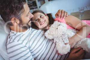 Father and daughter embracing on sofa