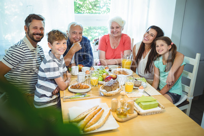 Portrait of happy multi-generation family sitting at breakfast table