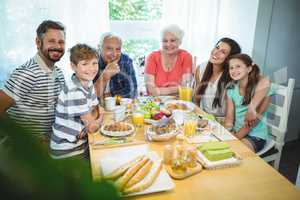 Portrait of happy multi-generation family sitting at breakfast table