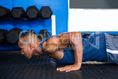 Side view of male athlete doing push-ups
