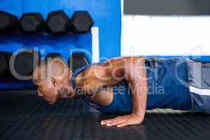 Side view of male athlete doing push-ups