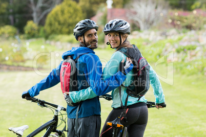 Biker couple with mountain bike in countryside