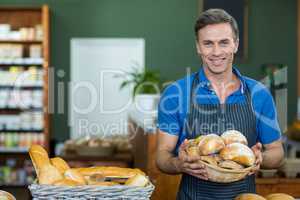 Portrait of male staff holding a basket of bread