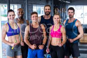 Portrait of smiling friends with jumping ropes in gym