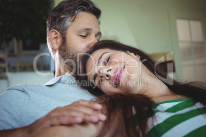 Happy couple lying on sofa in living room