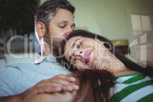 Happy couple lying on sofa in living room