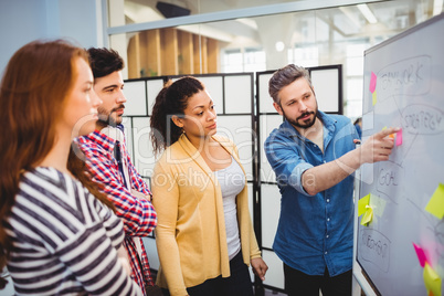 Executive explaining strategy on whiteboard in creative office