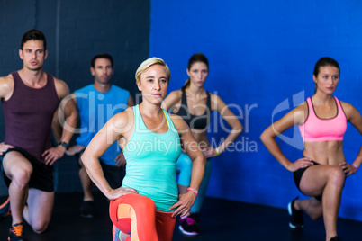 Determined athletes exercising in fitness studio