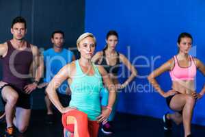 Determined athletes exercising in fitness studio